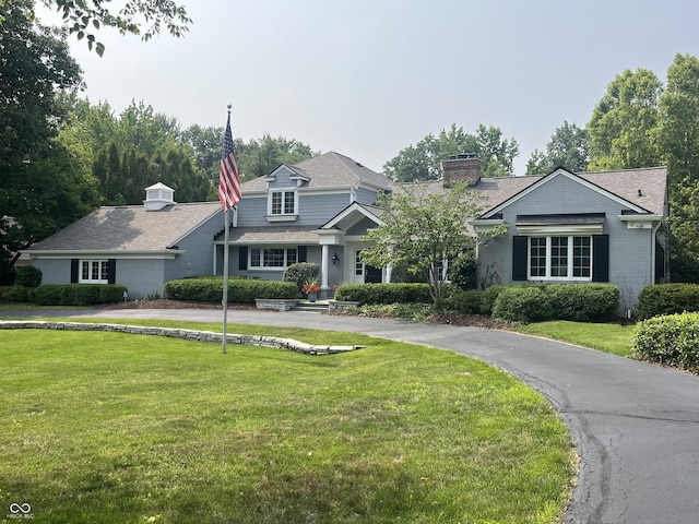 9510 Copley Dr, Indianapolis, IN 46260 - view of front facade featuring a front lawn, brick siding, and a chimney