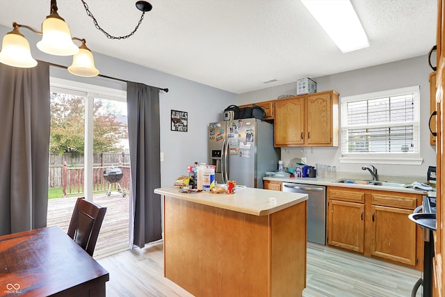 15264 Ten Point Dr, Noblesville, IN 46060 - kitchen with appliances with stainless steel finishes, healthy amount of natural light, a center island, light countertops, and a textured ceiling