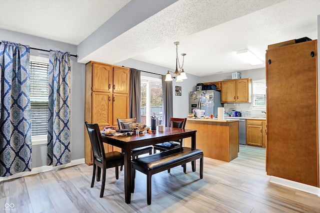 15264 Ten Point Dr, Noblesville, IN 46060 - dining space with light wood-type flooring, healthy amount of natural light, baseboards, and a textured ceiling
