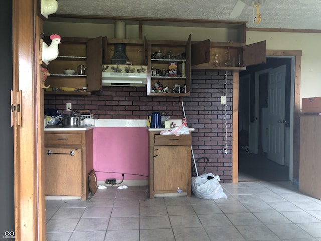 409 Parkway St, Whiteland, IN 46184 - kitchen with open shelves, light tile patterned floors, under cabinet range hood, brown cabinets, and a textured ceiling