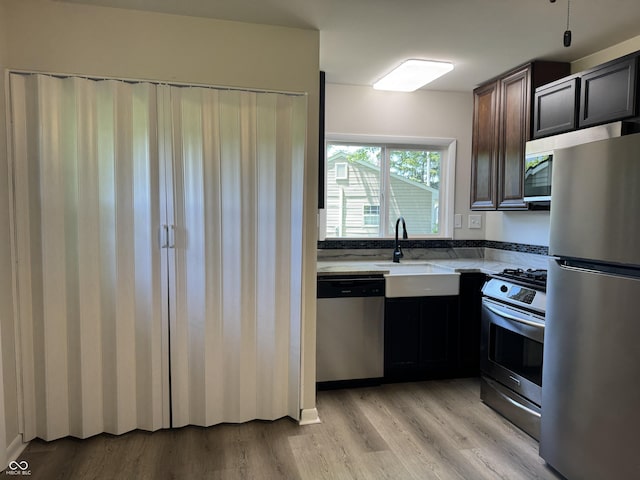 409 Parkway St, Whiteland, IN 46184 - kitchen with appliances with stainless steel finishes, a sink, light wood-type flooring, and light countertops