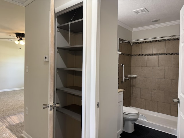 409 Parkway St, Whiteland, IN 46184 - bathroom with toilet, a ceiling fan, tiled shower, crown molding, and a textured ceiling