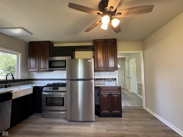 409 Parkway St, Whiteland, IN 46184 - kitchen with stainless steel appliances, a sink, a ceiling fan, and light wood-type flooring