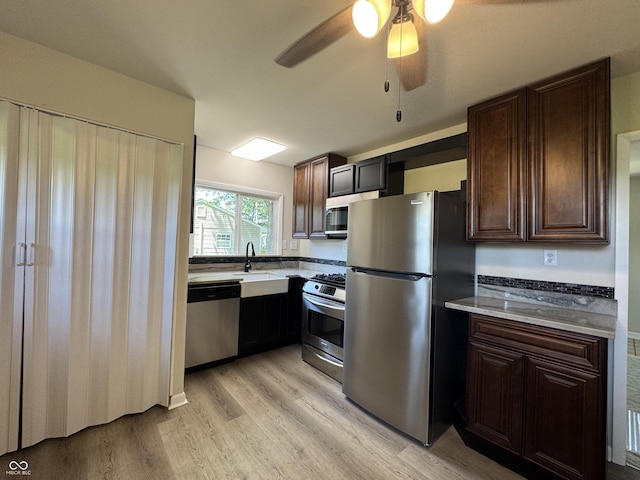 409 Parkway St, Whiteland, IN 46184 - kitchen featuring stainless steel appliances, light wood-style flooring, a sink, and dark brown cabinets