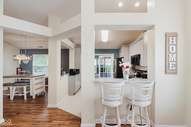 5939 Oberlies Way, Plainfield, IN 46168 - kitchen with freestanding refrigerator, a breakfast bar, healthy amount of natural light, and white cabinetry