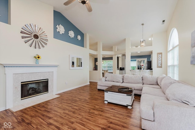 5939 Oberlies Way, Plainfield, IN 46168 - living room featuring high vaulted ceiling, wood finished floors, a ceiling fan, a tiled fireplace, and baseboards