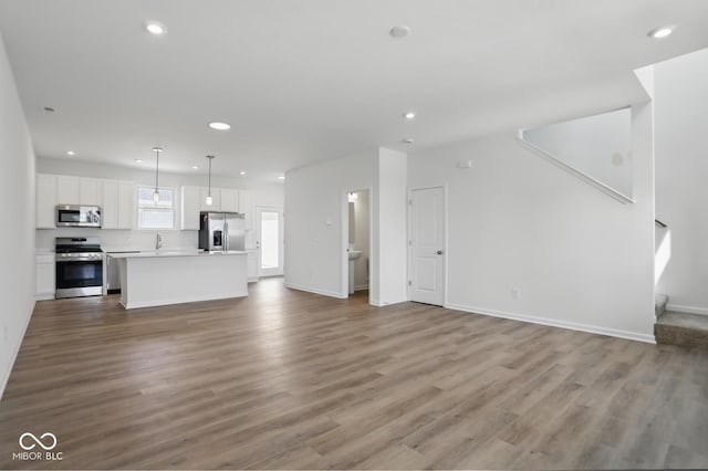 3931 Wren Dr, Brownsburg, IN 46112 - unfurnished living room with recessed lighting, wood finished floors, a sink, and baseboards