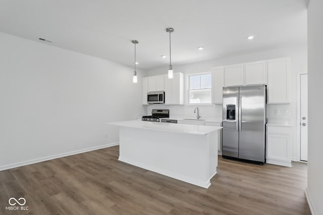 3931 Wren Dr, Brownsburg, IN 46112 - kitchen featuring appliances with stainless steel finishes, white cabinets, light countertops, wood finished floors, and recessed lighting