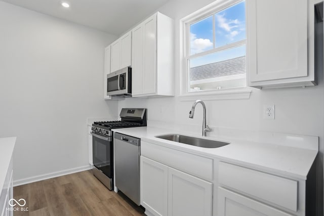 3931 Wren Dr, Brownsburg, IN 46112 - kitchen with a sink, appliances with stainless steel finishes, white cabinetry, wood finished floors, and light countertops