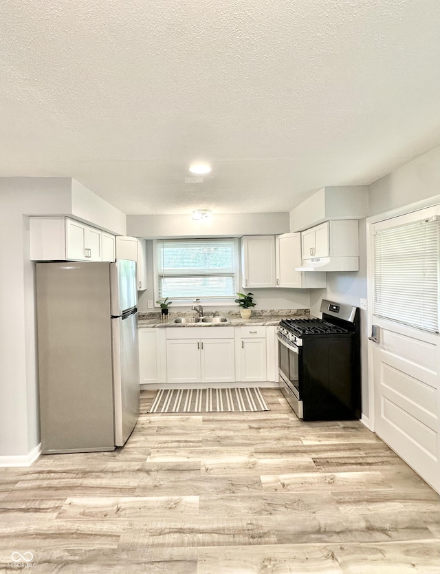 3594 Roland Dr, Kingman, IN 47952 - kitchen featuring stainless steel appliances, a sink, white cabinets, light wood finished floors, and a textured ceiling