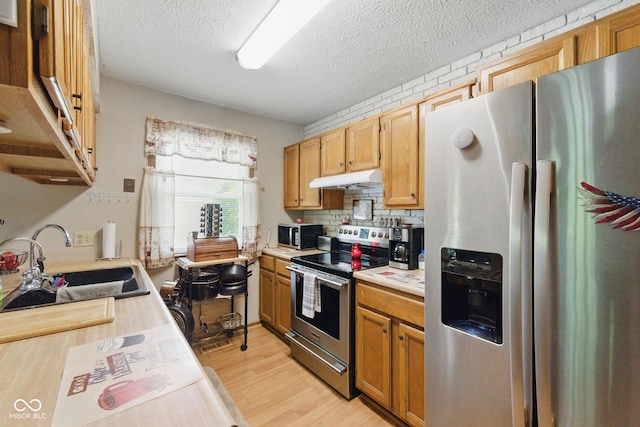 9130 E 18th St, Indianapolis, IN 46229 - kitchen featuring stainless steel appliances, a sink, under cabinet range hood, light countertops, and light wood-style flooring