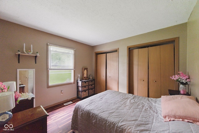 9130 E 18th St, Indianapolis, IN 46229 - bedroom with wood finished floors, two closets, baseboards, and a textured ceiling