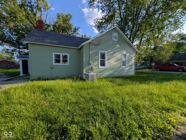 9712 N Price St, Knightsville, IN 47857 - view of side of home featuring central air condition unit, a chimney, and roof with shingles