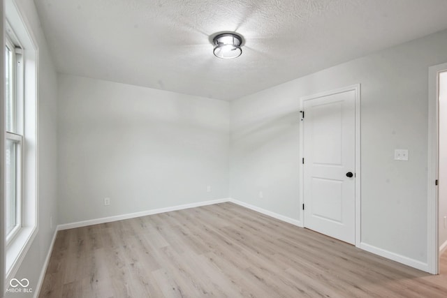 302 Highlawn Ave, Seymour, IN 47274 - unfurnished room featuring light wood finished floors, a textured ceiling, and baseboards