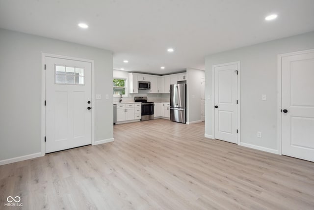 302 Highlawn Ave, Seymour, IN 47274 - unfurnished living room with light wood-style floors, recessed lighting, baseboards, and a sink