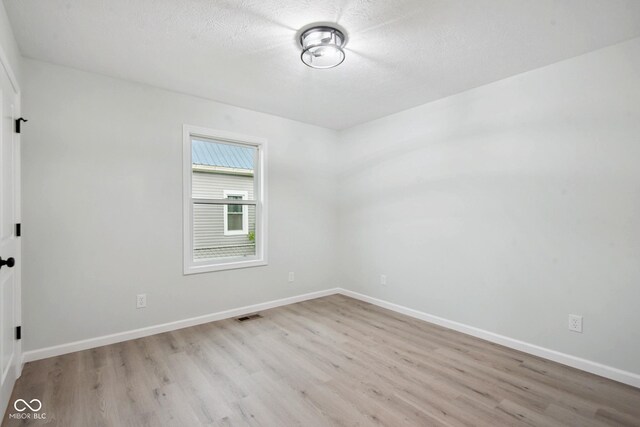 302 Highlawn Ave, Seymour, IN 47274 - unfurnished room featuring wood finished floors, baseboards, and a textured ceiling