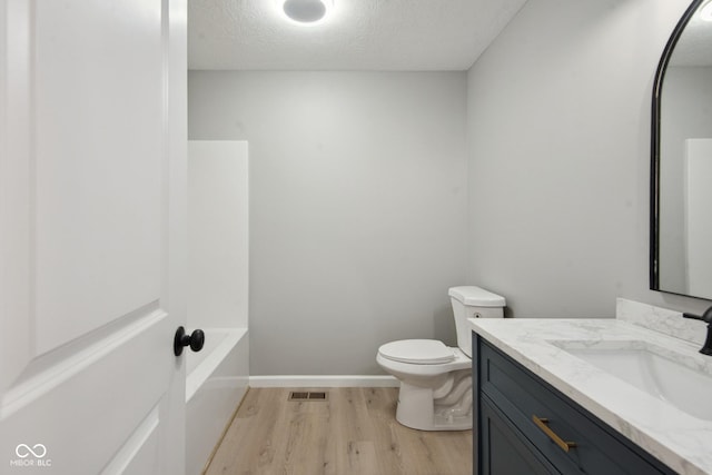302 Highlawn Ave, Seymour, IN 47274 - bathroom with wood finished floors, vanity, toilet, a textured ceiling, and baseboards