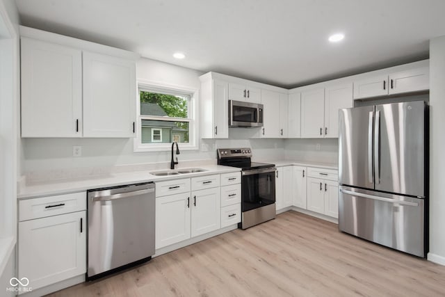 302 Highlawn Ave, Seymour, IN 47274 - kitchen with appliances with stainless steel finishes, a sink, light countertops, light wood-type flooring, and recessed lighting