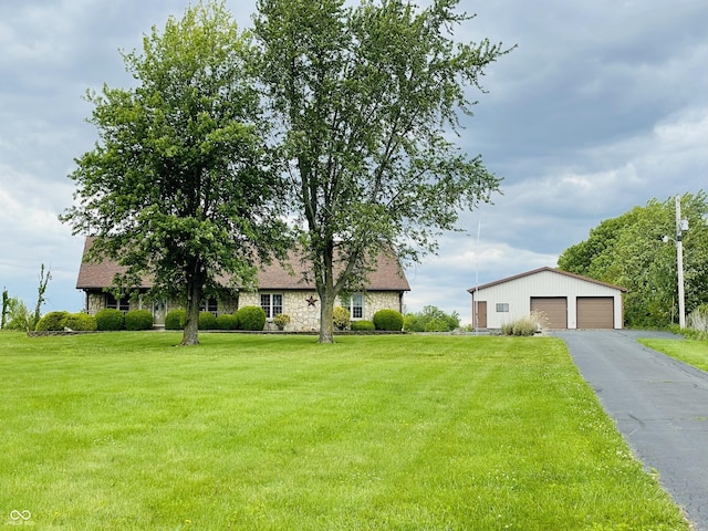 3925 S Flatrock River Rd, Rushville, IN 46173 - view of front facade featuring a garage, an outdoor structure, a front lawn, and stone siding
