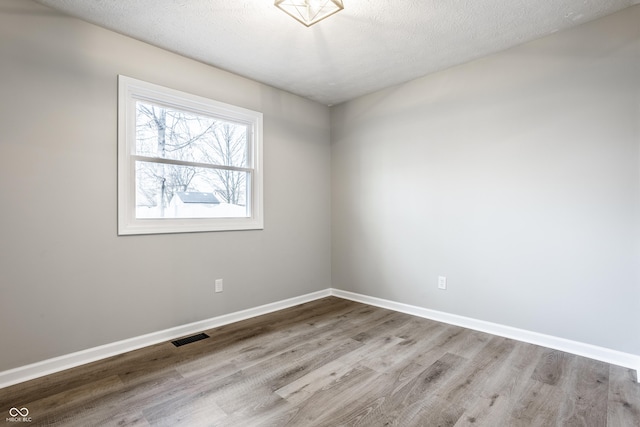 912 Delray Dr, Indianapolis, IN 46241 - unfurnished room with wood finished floors, baseboards, and a textured ceiling