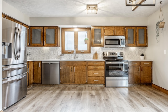 912 Delray Dr, Indianapolis, IN 46241 - kitchen featuring stainless steel appliances, a sink, brown cabinets, light countertops, and a textured ceiling