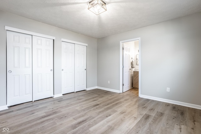 912 Delray Dr, Indianapolis, IN 46241 - unfurnished bedroom featuring multiple closets, wood finished floors, baseboards, and ensuite bath