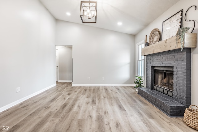 912 Delray Dr, Indianapolis, IN 46241 - unfurnished living room with a brick fireplace, wood finished floors, baseboards, a chandelier, and recessed lighting