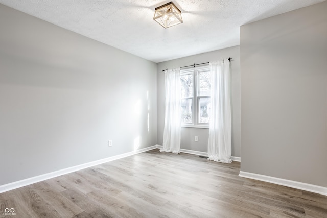 912 Delray Dr, Indianapolis, IN 46241 - spare room featuring wood finished floors, a textured ceiling, and baseboards