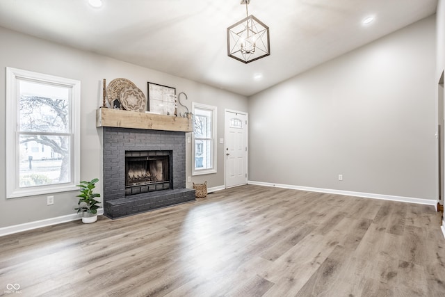 912 Delray Dr, Indianapolis, IN 46241 - unfurnished living room with baseboards, a brick fireplace, wood finished floors, recessed lighting, and a chandelier