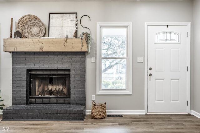 912 Delray Dr, Indianapolis, IN 46241 - entryway featuring wood finished floors, a brick fireplace, baseboards, and healthy amount of natural light