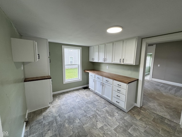 707 N Water St, Hillsboro, IN 47949 - kitchen featuring wood counters, white cabinetry, baseboards, and a textured ceiling