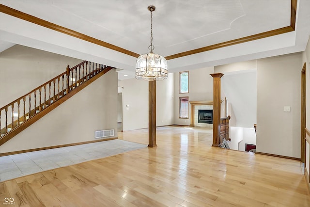 1344 S Fox Paw Dr, New Palestine, IN 46163 - unfurnished dining area featuring hardwood / wood-style floors, a chandelier, a tiled fireplace, stairs, and crown molding