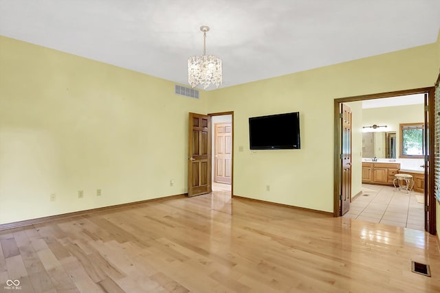 1344 S Fox Paw Dr, New Palestine, IN 46163 - unfurnished bedroom featuring a chandelier, light wood-style flooring, and ensuite bathroom