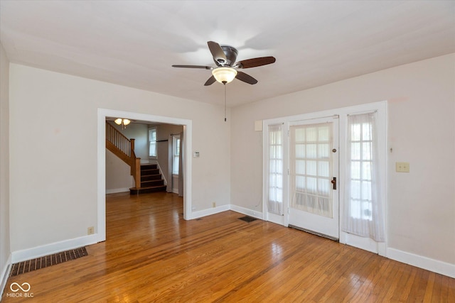 1015 Fairfield Ave, Indianapolis, IN 46205 - empty room featuring stairs, light wood finished floors, healthy amount of natural light, and ceiling fan