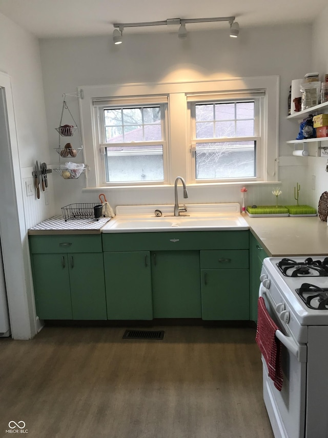 1015 Fairfield Ave, Indianapolis, IN 46205 - kitchen featuring green cabinetry, white gas range, dark wood-type flooring, light countertops, and a sink