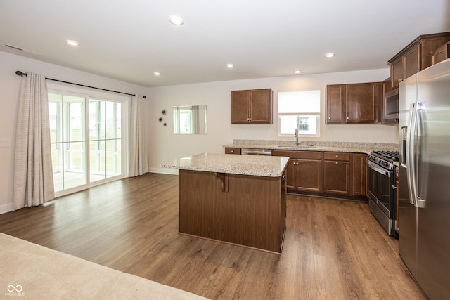 1863 River Birch Dr, Greenfield, IN 46140 - kitchen featuring stainless steel appliances, a sink, dark wood-type flooring, a center island, and light stone counters