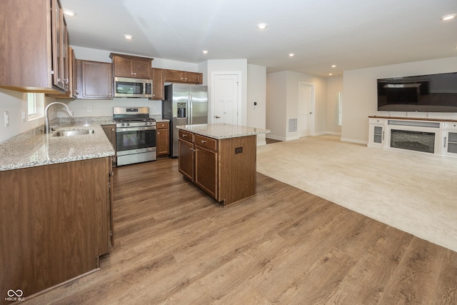 1863 River Birch Dr, Greenfield, IN 46140 - kitchen featuring stainless steel appliances, a sink, a center island, open floor plan, and light wood-style flooring