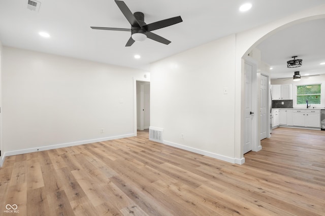 5422 Orange St, Indianapolis, IN 46203 - empty room with ceiling fan, arched walkways, recessed lighting, light wood-style floors, and baseboards
