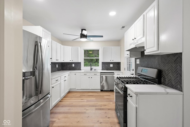 5422 Orange St, Indianapolis, IN 46203 - kitchen with stainless steel appliances, a ceiling fan, under cabinet range hood, a sink, and white cabinets