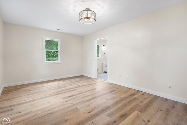 5422 Orange St, Indianapolis, IN 46203 - empty room with light wood-style floors, a chandelier, and baseboards