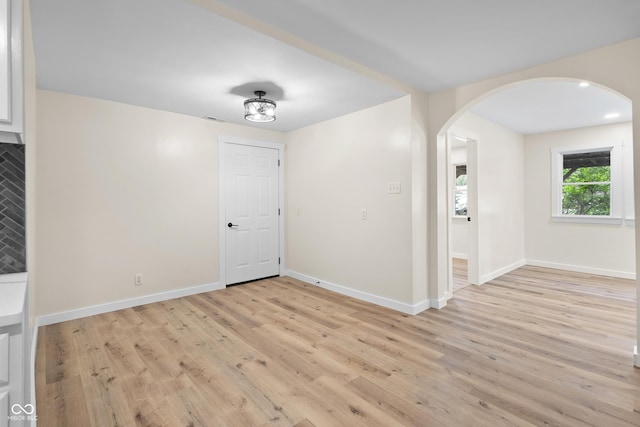 5422 Orange St, Indianapolis, IN 46203 - spare room featuring arched walkways, light wood-style floors, and baseboards