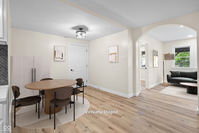 5422 Orange St, Indianapolis, IN 46203 - dining area with arched walkways, baseboards, and light wood-style flooring