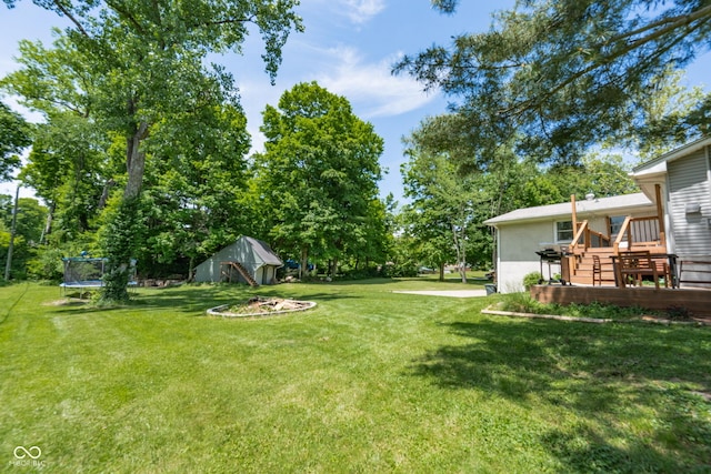 6799 Lakeshore Dr, Avon, IN 46123 - view of grassy yard with a trampoline and a deck