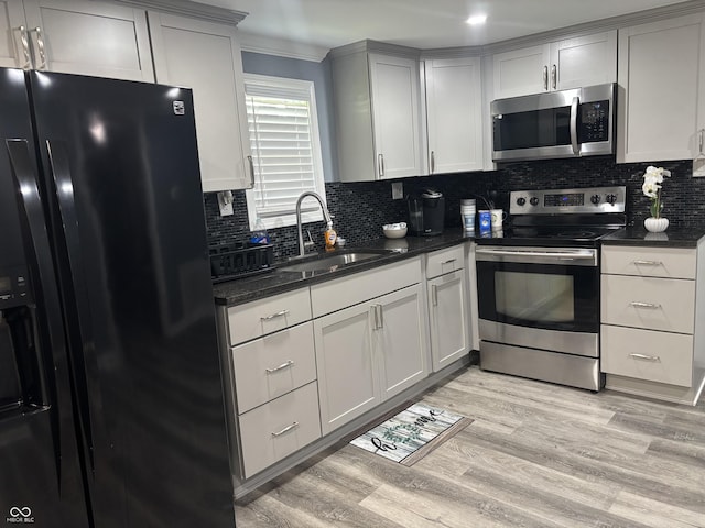 3041 S Rybolt Ave, Indianapolis, IN 46241 - kitchen with stainless steel appliances, a sink, tasteful backsplash, and light wood-style floors