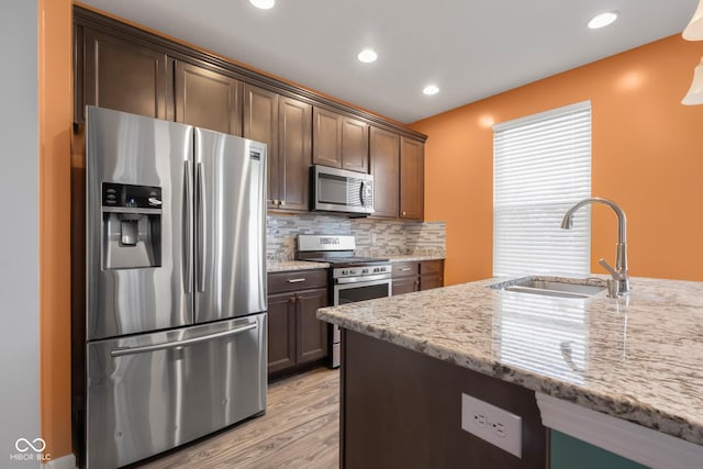 2502 Creekland Dr, Columbus, IN 47201 - kitchen featuring stainless steel appliances, a sink, light wood finished floors, light stone counters, and recessed lighting