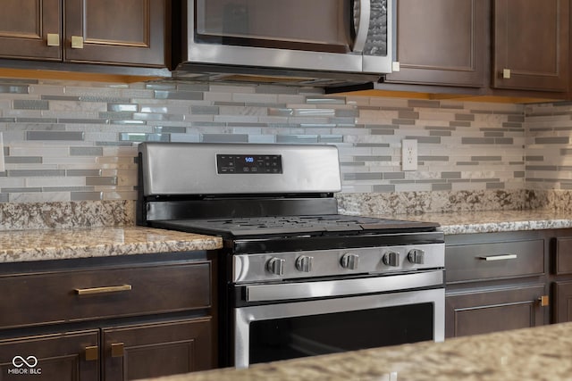 2502 Creekland Dr, Columbus, IN 47201 - kitchen featuring stainless steel appliances, tasteful backsplash, dark brown cabinets, and light stone countertops