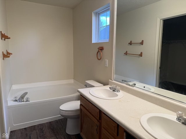 1009 Springwater Rd, Kokomo, IN 46902 - full bathroom with a garden tub, toilet, wood finished floors, double vanity, and a spacious closet
