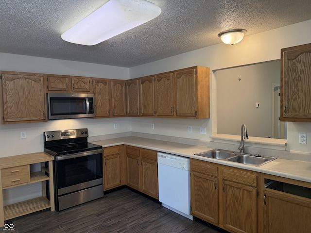 1009 Springwater Rd, Kokomo, IN 46902 - kitchen with stainless steel appliances, a sink, light countertops, dark wood finished floors, and a textured ceiling