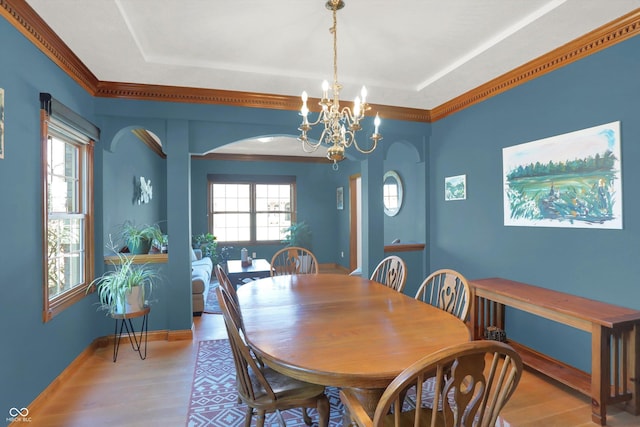 545 Walnut Woods Dr, Greenwood, IN 46142 - dining space featuring wood finished floors, a chandelier, arched walkways, baseboards, and crown molding