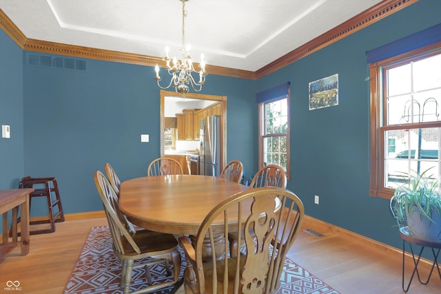 545 Walnut Woods Dr, Greenwood, IN 46142 - dining room featuring light wood-type flooring, a chandelier, a tray ceiling, and baseboards